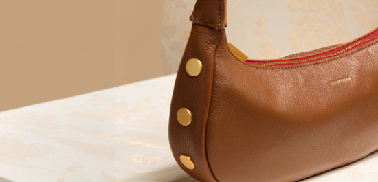 Detail image of Becker in Mahogany Pebble Brushed gold red zip showing Brushed gold rivets on side. 