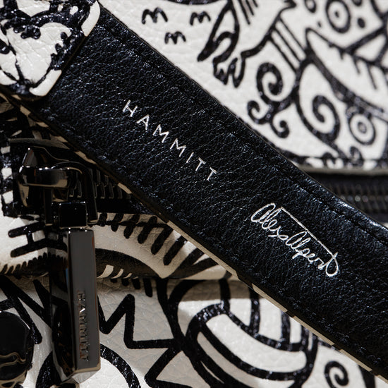 Image of close up detail image of Hammitt logo and Alex Alpert's signature on strap for Alex Alpert Collection. 