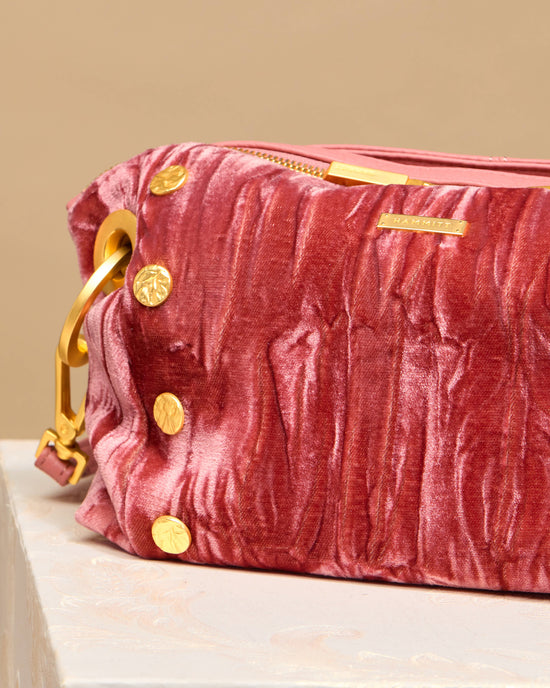 Detail image of Daniel Crossobody Clutch in Curtain Call Pink hammered gold. 